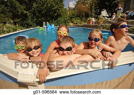 Picture - Friends playing in a backyard pool. Fotosearch