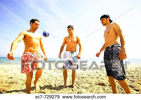 Stock Photo - Friends playing on beach. Fotosearch