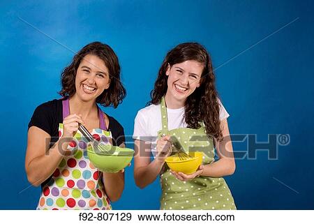 Stock Photo - friends posing with cooking Bowls, Whisks, Aprons, fun, game, smiles, happy, teenagers. Fotosearch
