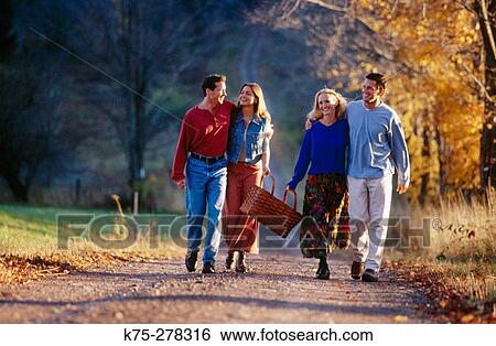 Friends strolling a country road View Large Photo Image Stock Photograph - Friends strolling a country road. Fotosearch