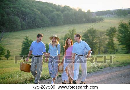 friends strolling in the countryside to a picnic View Large Photo Image Stock Photo - friends strolling in the countryside to a picnic. Fotosearch