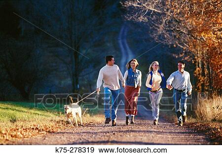 Friends walking country road with their dog View Large Photo Image Stock Photo - Friends walking country road with their dog. Fotosearch
