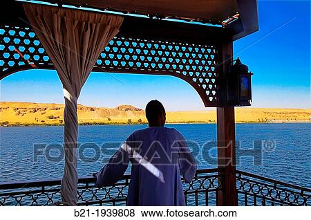 From the Yacouta Hotel dahabiya boat (design by Mrs. Dora El Chiaty) on the Nile river, at Luxor, Egypt View Large Photo Image Stock Photo - From the Yacouta Hotel dahabiya boat (design by Mrs. Dora El Chiaty) on the Nile river, at Luxor, Egypt. Fotosearch