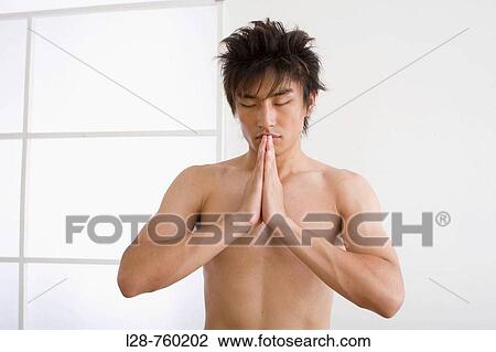 Stock Image - Front view portrait of young man performing yoga. Fotosearch