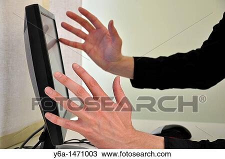 Stock Image - Frustrated businessman in front of computer focus on hands. Fotosearch