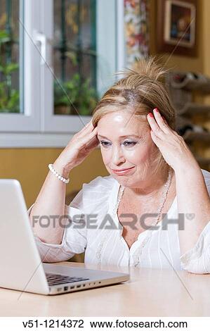 Frustrated senior woman using laptop View Large Photo Image Stock Image - Frustrated senior woman using laptop. Fotosearch