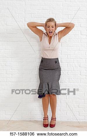 Frustrated young woman holding her ears View Large Photo Image Stock Photograph - Frustrated young woman holding her ears. Fotosearch