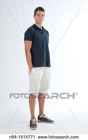 Stock Image - Full-body photograph of a teenage boy standing with hands in pockets.. Fotosearch