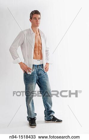 Stock Image - Full-body photograph of a teenage boy in jeans and white shirt open.. Fotosearch