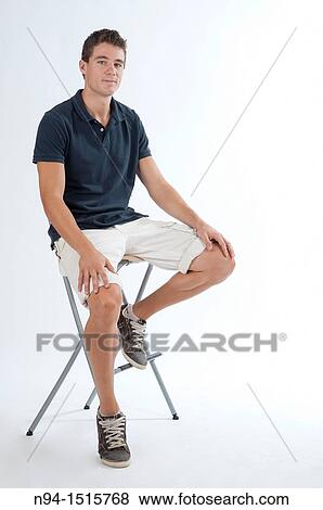 Full-body photograph of a teenage boy sitting on a stool. View Large Photo Image Stock Photo - Full-body photograph of a teenage boy sitting on a stool.. Fotosearch