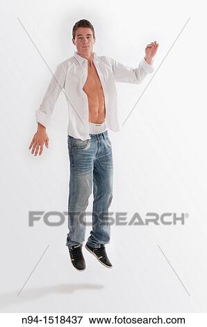 Full-body photograph of a teenage boy, jumping, with jeans and white shirt open. View Large Photo Image Stock Photo - Full-body photograph of a teenage boy, jumping, with jeans and white shirt open.. Fotosearch