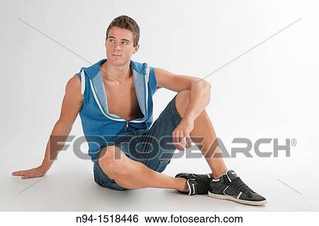 Full-body photograph of a teenage boy sitting, in short jeans and sleeveless blue vest. View Large Photo Image Stock Photograph - Full-body photograph of a teenage boy sitting, in short jeans and sleeveless blue vest.. Fotosearch
