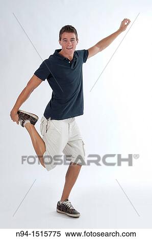 Stock Photography - Full-body photograph of a teenage boy standing with a jump or making a pirouette.. Fotosearch