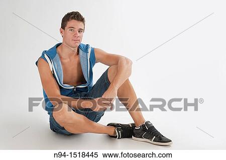 Full-body photograph of a teenage boy sitting, in short jeans and sleeveless blue vest. View Large Photo Image Stock Photography - Full-body photograph of a teenage boy sitting, in short jeans and sleeveless blue vest.. Fotosearch