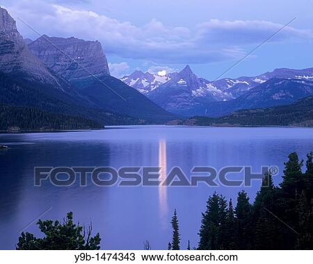 Full moon sets at dawn over Fusillade Mountain and St Mary Lake, Glacier National Park, Montana, USA View Large Photo Image Stock Image - Full moon sets at dawn over Fusillade Mountain and St Mary Lake, Glacier National Park, Montana, USA. Fotosearch
