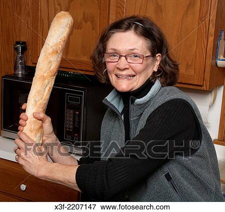 Stock Photo - Fun loving hostess playing ball in the kitchen with our baguette dinner bread. St Paul Minnesota MN USA.. Fotosearch