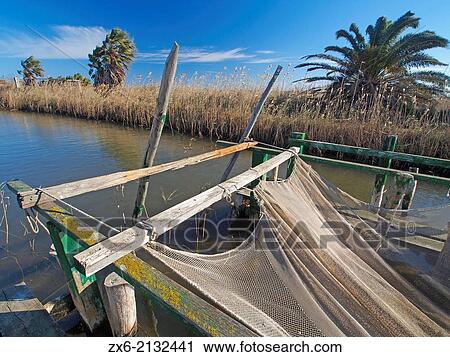 Funnel type fishing construction at irrigation ditch. La Marquesa Beach. Ebro River Delta Natural Park, Tarragona province, Catalonia, Spain. View Large Photo Image Stock Image - Funnel type fishing construction at irrigation ditch. La Marquesa Beach. Ebro River Delta Natural Park, Tarragona province, Catalonia, Spain.. Fotosearch