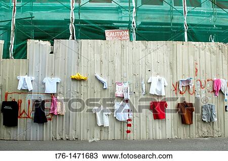 Stock Image - funny place to hang laundry next to warning sign and construction site in Georgetown, Penang, Malaysia. Fotosearch