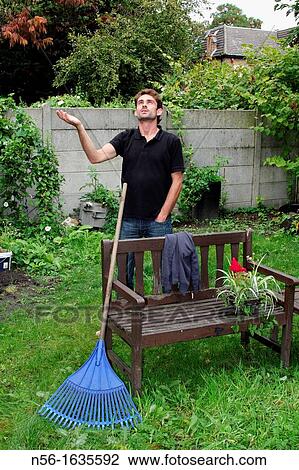 GARDENER CHECKING THE WEATHER FORECAST IN ENGLAND, LONDON View Large Photo Image Stock Image - GARDENER CHECKING THE WEATHER FORECAST IN ENGLAND, LONDON. Fotosearch