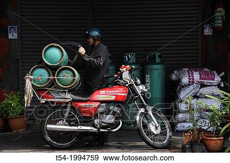Stock Photo - Gas bike is delivering gas bottles. Fotosearch