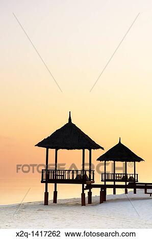 Stock Image - Gazebo with straw roof at a resort in the Maldives. Fotosearch