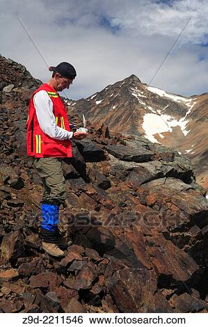 Stock Photograph - Geologist doing fieldwork, Hudson Bay Mountain, Smithers, British Columbia.. Fotosearch