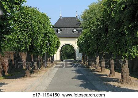 Stock Image - Germany, Dormagen, North Rhine-Westphalia, Dormagen-Delhoven, monastery Knechtsteden, premonstratensian abbey, Spiritans Order, convent wall, archway, trees, tree-lined walk. Fotosearch