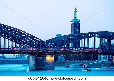 Stock Photograph - Germany, Nordrhein-Westfalen, Cologne, Hohenzollern Bridge and Messeturm tower, dusk. Fotosearch