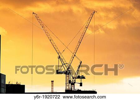 Giant cranes on the South Bank of the Thames in London, England, caught in a Winter sunset View Large Photo Image Stock Image - Giant cranes on the South Bank of the Thames in London, England, caught in a Winter sunset. Fotosearch