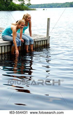 girl 13, girl 18 sitting on dock together View Large Photo Image Stock Image - girl 13, girl 18 sitting on dock together. Fotosearch