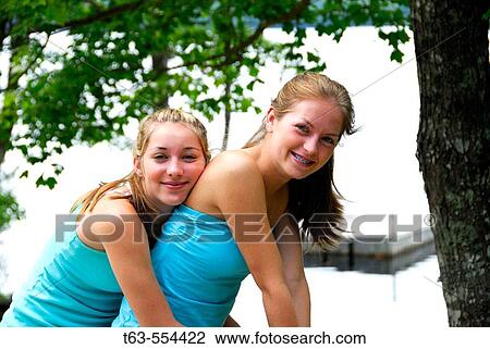 girl 13 girl 18 sitting together on deck at the cottage View Large Photo Image Stock Image - girl 13 girl 18 sitting together on deck at the cottage. Fotosearch
