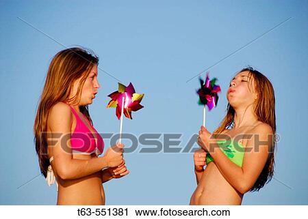girl 13, girl 18 yrs blowing on pinwheels at beach View Large Photo Image Stock Image - girl 13, girl 18 yrs blowing on pinwheels at beach. Fotosearch