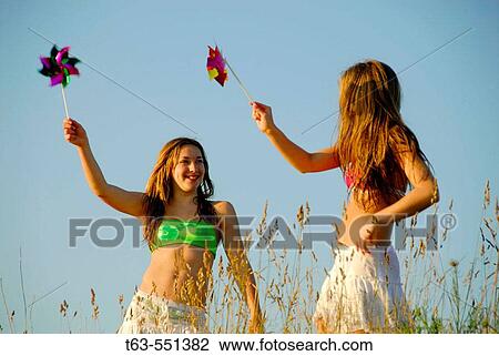girl 13, girl 18 yrs playing together with pinwheels at the beach View Large Photo Image Stock Image - girl 13, girl 18 yrs playing together with pinwheels at the beach. Fotosearch