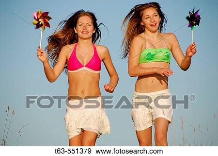 girl 13, girl 18 yrs running with pinwheels at the beach View Large Photo Image Stock Photo - girl 13, girl 18 yrs running with pinwheels at the beach. Fotosearch