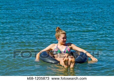 girl, 14, floating in a lake on an inner tube in southern Alberta, Canada View Large Photo Image Stock Image - girl, 14, floating in a lake on an inner tube in southern Alberta, Canada. Fotosearch