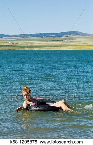 girl, 14, floating in a lake on an inner tube in southern Alberta, Canada View Large Photo Image Stock Photography - girl, 14, floating in a lake on an inner tube in southern Alberta, Canada. Fotosearch