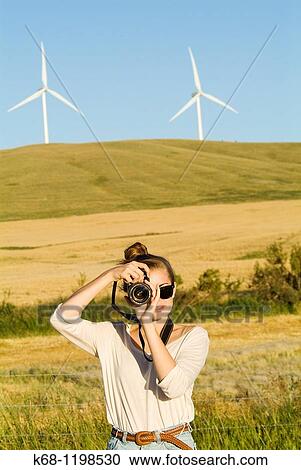 girl, 14, with camera, in a field in southern Alberta, Canada, with wind turbines in background. View Large Photo Image Stock Image - girl, 14, with camera, in a field in southern Alberta, Canada, with wind turbines in background.. Fotosearch