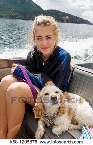 Stock Photo - girl, 14, with her cocker spaniel, in a boat on a lake. Fotosearch