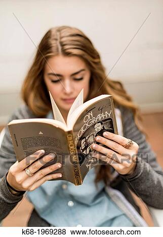 Stock Photo - Girl, 17, reading the book, On Photography by Susan Sontag. Fotosearch