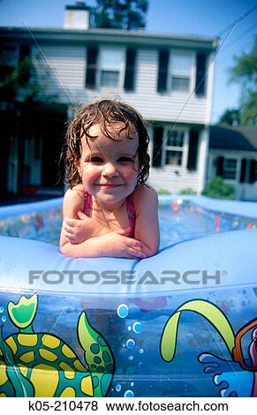 Stock Photo - Girl (3yr) in an inflatable pool. Fotosearch
