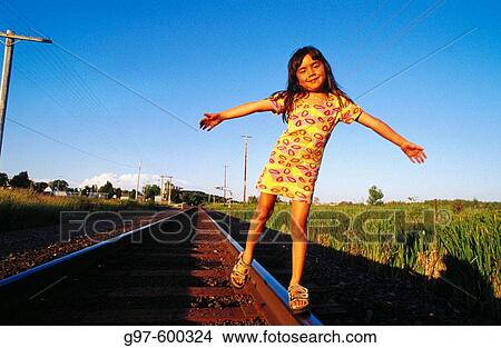 Picture - Girl, 6 years old, balancing on railroad track. Fotosearch