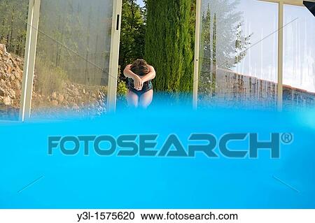 Girl about to plunge into a swimming pool View Large Photo Image Stock Image - Girl about to plunge into a swimming pool. Fotosearch