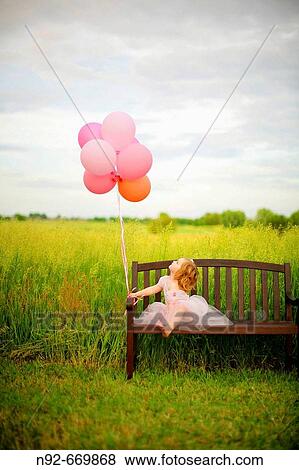 Girl, age 3 looking at balloons. View Large Photo Image Stock Photo - Girl, age 3 looking at balloons.. Fotosearch