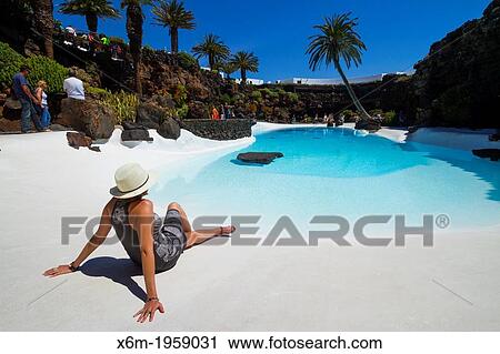 Stock Image - Girl and a pool. Los Jameos del Agua.. Fotosearch