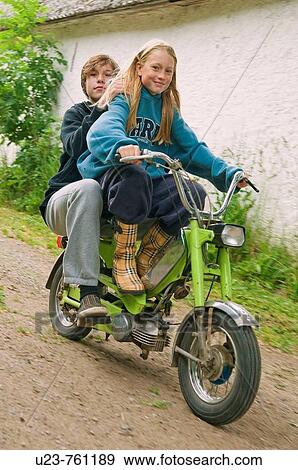 Girl and boy on a moped, girl driving. View Large Photo Image Stock Photo - Girl and boy on a moped, girl driving.. Fotosearch