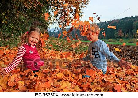 girl and boy playing in pile of leaves, fall Zuerich, Switzerland View Large Photo Image Picture - girl and boy playing in pile of leaves, fall Zuerich, Switzerland. Fotosearch