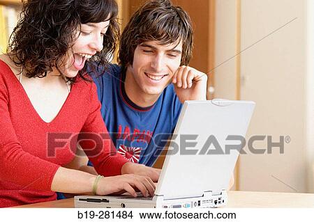 Picture - Girl and boy with laptop. Fotosearch