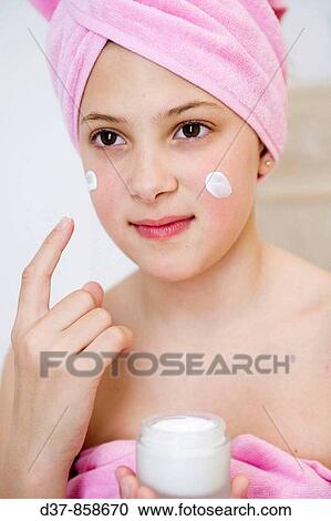 Girl applying cream on her face View Large Photo Image Stock Image - Girl applying cream on her face. Fotosearch
