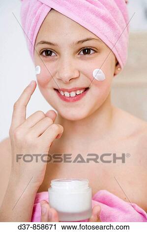 Girl applying cream on her face View Large Photo Image Stock Image - Girl applying cream on her face. Fotosearch