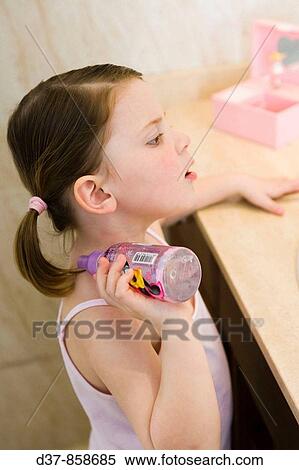 Stock Photography - Girl applying perfume in the bathroom. Fotosearch